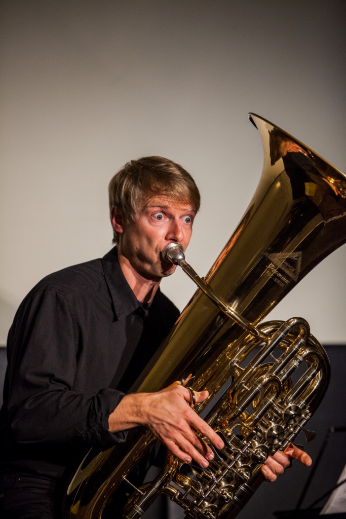 Mann bläst in eine Tuba.